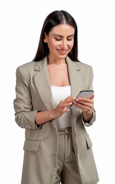 Bej takım elbiseli, gülümseyen, cep telefonu kullanan bir ofis kadını. Sekreter, beyaz arka planda izole edilmiş planlar ve yeni fikirler üretiyor. Teknoloji ve başarı kavramı