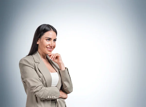 面带微笑的欧洲迷人的黑发女人的画像 穿着正式的橄榄绿外套 双手托着下巴 思考着职业机会和新的商业理念 浅蓝色墙 — 图库照片