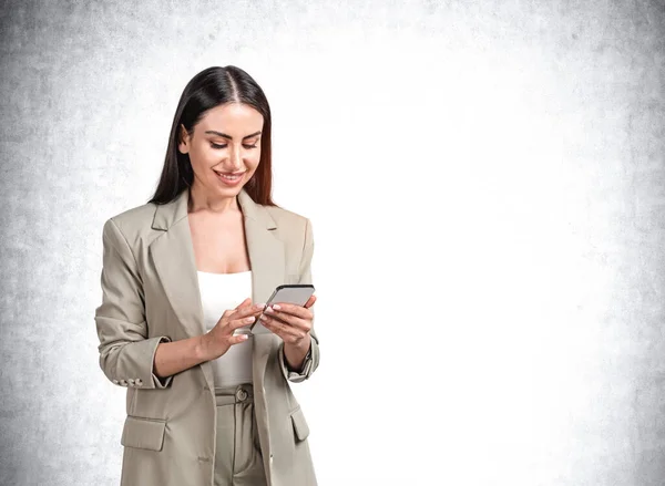 Atrakcyjna Młoda Uśmiechnięta Bizneswoman Formalnym Oliwkowym Zielonym Garniturze Trzyma Smartfona — Zdjęcie stockowe