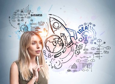 Çekici, düşünceli, yeni bir iş kurma hayali kuran sarışın kadın. Başarı kavramı ve yeni iş projesi. Açık mavi duvara çizilmiş beyin, roket ve dünya gezegenli iş çizimi