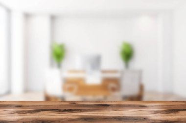 Ön planda ahşap masa, masa, koltuk ve masaüstü bilgisayarlı bulanık danışma odasının arka planı. Mobilya ve pencere, ürünün gösterimi için model