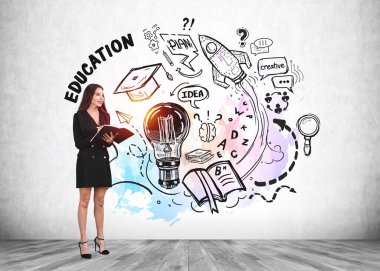 Resmi takım elbiseli çekici bayan öğretmen kitap, plan, roket fırlatma, mezuniyet şapkası ve arka planda ahşap zemin ile renkli çizimin önünde duruyor. Bilgi ve eğitim kavramı