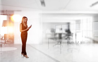 Tulum giymiş bir ofis çalışanı, iş odasında mobilyalı bir telefon kullanıyor. İş sekreteri ve teknoloji kavramı