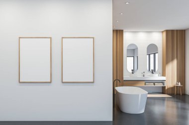 Banyo içi beyaz küvetli ve iki lavabo aynalı, masa havlularla dolu. Gri beton zemin ve ayak havlusu. İki çerçeve beyaz duvarda 3 boyutlu olarak oluşturuldu.