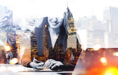 Resmi takım elbiseli bir iş kadını akıllı telefondan mesaj yazıyor. Ofis işyeri ve arka planda New York şehri gökdelen panoramik manzarası. Çalışma süreci kavramı