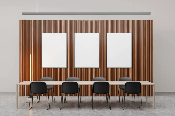 Meeting room interior with three white boards, linear lighting, table with eight chairs next to wooden wall partition and concrete floor. Concept of modern office design. 3d rendering