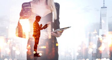 Dijital cihaz kullanan ofis kadını, iş adamlarının iş raporlarını okuduğu siluet, New York şehri manzarası ve bokeh ışıkları iki kez görülüyor. Ağ ve ortaklık kavramı