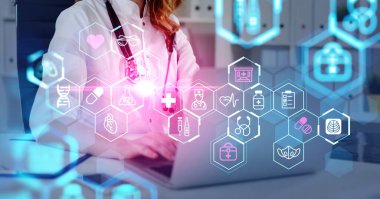Beyaz takım elbiseli kadın doktor laptopta çalışıyor ve daktilo ediyor. Önplanda DNA, şırınga, hap, maske, kalp ve termometre ikonları ile dijital arayüz. Sağlık bakımı ve tanılama kavramı