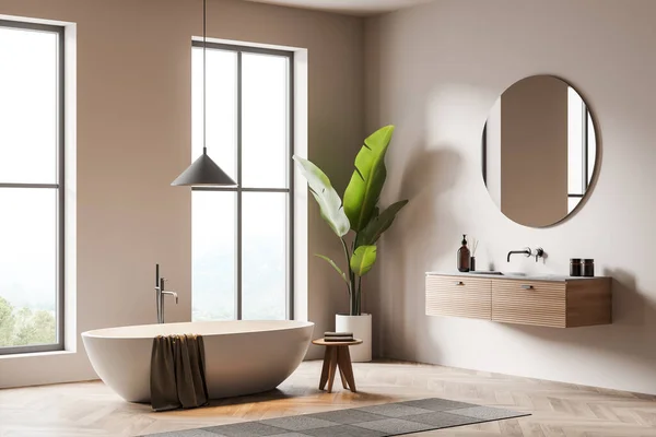 白い浴槽とベージュの洗濯室のインテリア 丸い鏡でシンク 寄木細工の床に足のタオル デッキでの入浴アクセサリー サイドビュー 田舎のパノラマウィンドウ 3Dレンダリング — ストック写真
