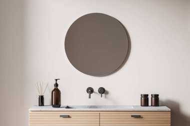 İçi lavabo ve duvarında yuvarlak ayna olan bej çamaşır odası, yakın plan. Sabun şişesi, krema ve kamış ayırıcı güvertede, ön manzara. 3B görüntüleme