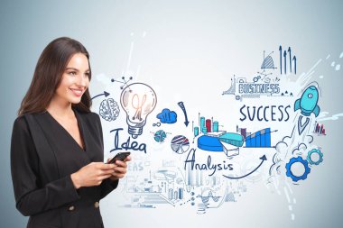 Resmi takım elbiseli, gülümseyen genç çekici iş kadını elinde akıllı telefon tutuyor. Ampullü çizim, arka planda roket fırlatma. Hayal gücü kavramı ve yaratıcı fikirler için ilham.