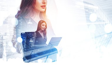 Ofisteki kadın dizüstü bilgisayar kullanıyor, gülümsüyor. İki ofis çalışanı birlikte çalışıyor. Şehir manzarası ve bokeh ışıkları iki kez görülmüş. Ağ ve ortaklık kavramı