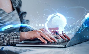 Resmi elbise giyen iş kadını dizüstü bilgisayarda mesaj yazıyor. Arka planda masa olan ofis işyeri. Metaevren, dijital arayüz ve uluslararası iletişim kavramı