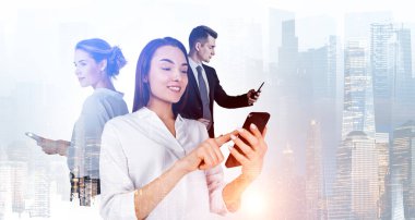 Beyaz gömlek giyen iş kadınları akıllı telefonlar kullanarak iş adamlarıyla birlikte çalışırlar. Arka planda Singapur gökdelenleri var. Ticaret ve iş birliğinde modern teknoloji kavramı
