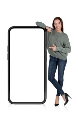 Gündelik kıyafet giyen genç ve çekici bir iş kadını boş akıllı telefon teklifine dokunuyor. Fotokopi alanı gibi. Hayal gücü kavramı, yaratıcı fikirler için ilham kaynağı. Beyaz arkaplan üzerinde izole edilmiş