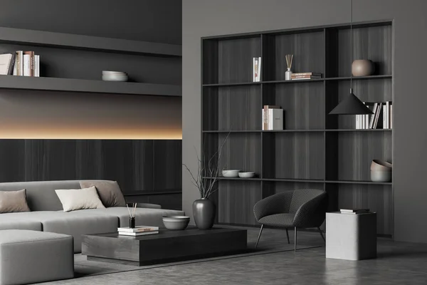 Dark living room interior with sofa and armchair, side view, coffee table and shelf with decoration, carpet on grey concrete floor. Relaxing room in modern apartment, 3D rendering