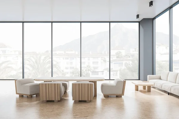 Meeting room interior with armchairs with table, sofa and coffee table on beige concrete floor. Panoramic window on countryside. Modern chill zone, 3D rendering