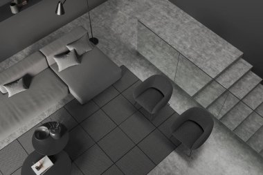 Koyu renk oturma odası manzarası kanepe ve iki koltuk dekoratif kahve masası, gri beton zeminde halı. Merdiven ve cam bölme, 3 boyutlu görüntüleme