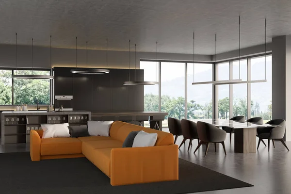 Dark kitchen interior with corner sofa and chairs, side view, table on grey concrete floor. Panoramic window with countryside. Open space with modern furniture. 3D rendering