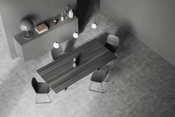 Dark meeting room interior with black chairs and wooden table, top view, dresser with art decoration, grey concrete floor. Minimalist guest area, 3D rendering