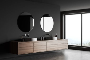 Karanlık otel çamaşır odasının içinde çift lavabo, yuvarlak aynalar, yan görüş, gri beton zemin. Kırsal manzaralı panoramik pencere. 3B görüntüleme
