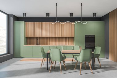 Green kitchen interior with chairs and dining table on grey concrete floor, eating space with kitchenware, panoramic window on countryside. 3D rendering