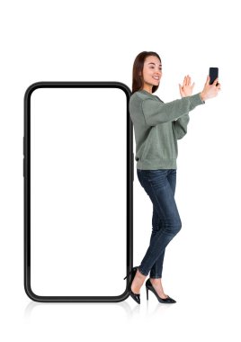Young woman with device, making video call waving hand, isolated over white background. Phone mockup copy space screen. Concept of new mobile app and update