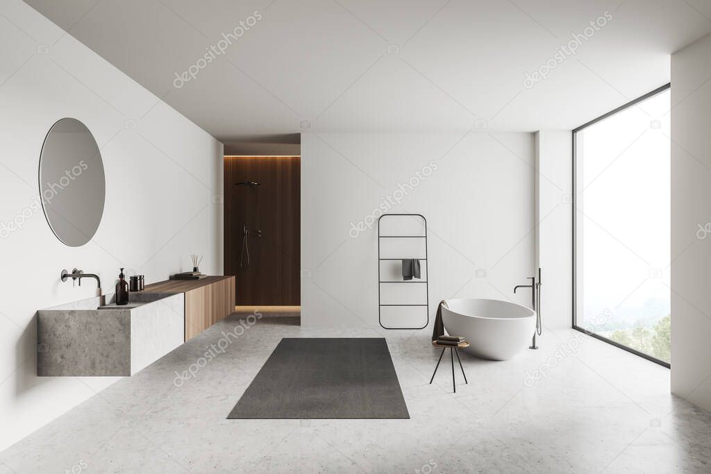 White bathroom interior with bathtub mixer mounted on grey concrete floor, sink and shower with towel rail ladder. Panoramic window on countryside. Open space in hotel studio. 3D rendering