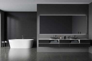 Dark hotel bathroom interior with double sink and mirror with backlight, bathtub on grey concrete floor. Table with towel and bathing accessories on deck. 3D rendering