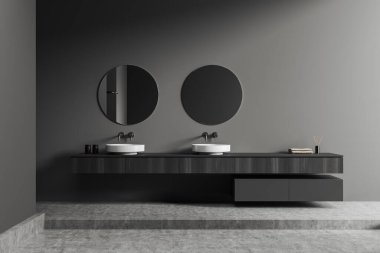 Dark bathroom interior with double sink and two round mirror, podium and grey concrete floor. Wooden dresser with bathing accessories, towel and reed diffuser. 3D rendering