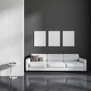 Dark relaxing zone interior with white sofa, coffee table on grey concrete floor, accent wall. Three mock up blank posters in row, 3D rendering