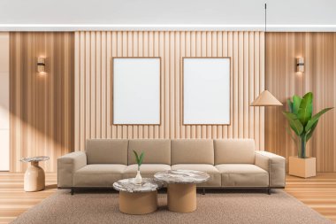 İçinde kanepe, sehpa, halı ve ahşap döşeme olan bej bir oturma odası. Sakin ol ve sırada iki tane poster var. 3B görüntüleme