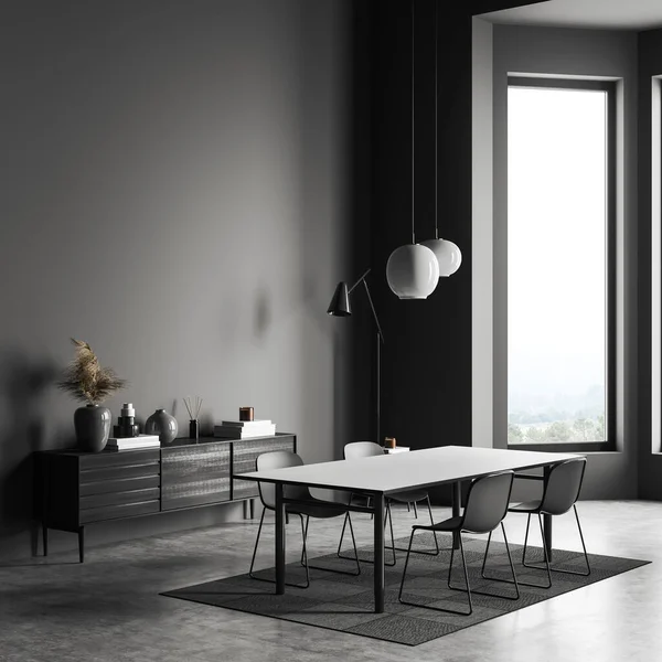 Corner view on dark dining room interior with empty grey wall, sideboard with books, dining table with chairs, crockery and concrete floor. Concept of place for reading. Mock up. 3d rendering