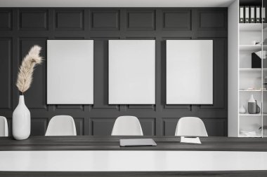 Karanlık ofis içinde üç boş beyaz poster, raflar, büyük toplantı panosu, dizüstü bilgisayar, dosya ve ahşap zemin. Çalışma sürecinin konsepti. Model yap. 3d oluşturma