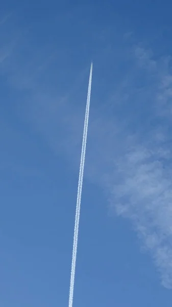 ジニタでは飛行機のシルエットが見え 青い空に白い歩道が残っています — ストック写真
