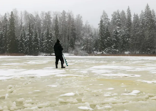 Ice fishing. Fisherman walking on a frozen lake, Fisherman enjoying the day, fishing on the ice, winter day