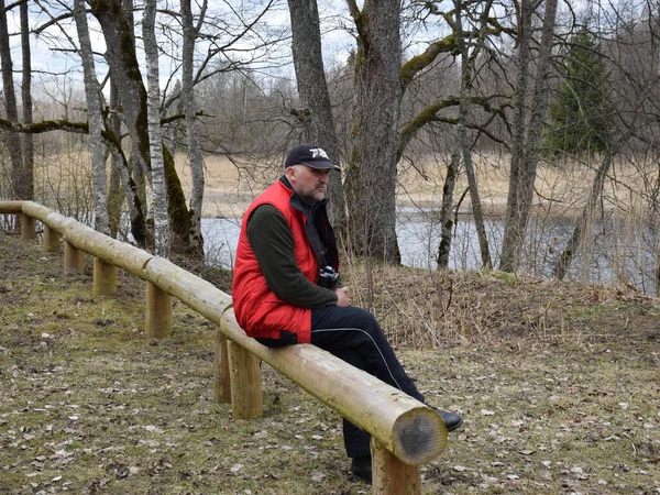 Figura Hombre Sentado Una Cerca Madera Orilla Del Río Primavera —  Fotos de Stock