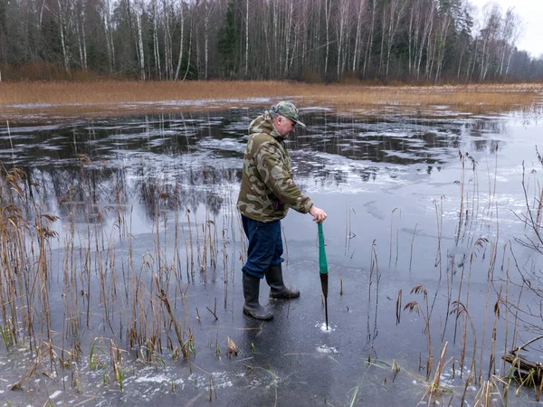 Vinterfiskare Kontrollerar Isens Styrka Och Tjocklek Bländning Isytan Nakna Trädsiluetter — Stockfoto