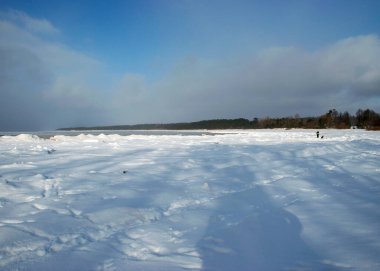 Karda ayak izleri olan güzel kış manzarası, beyaz kar örtülü kumullar, deniz kıyıları, kış günü