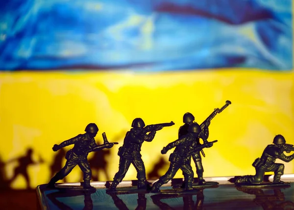 children\'s toy soldiers and shadow games on the colors of the Ukrainian flag, the concept of NO war in Ukraine, stop the war
