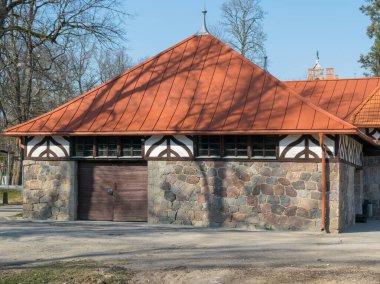 Kırmızı çatılı eski bir taş evin resmi.