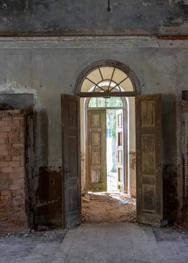 Terk edilmiş bir Ortodoks kilisesindeki eski kemerli bir kapının fotoğrafı. Eski harap duvarlar.