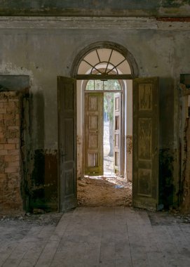 Terk edilmiş bir Ortodoks kilisesindeki eski kemerli bir kapının fotoğrafı. Eski harap duvarlar.