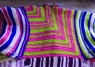 Renkli grafik tasarımı, örgü dokusu, arka planı olan yama işi bir yorganın yakın plan resmi