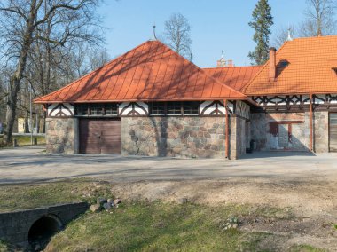 Kırmızı çatılı eski bir taş evin resmi.