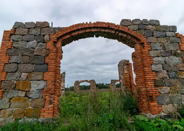 Taş ve tuğla ahır kalıntıları olan arazi, kırmızı tuğlalarla örülmüş eski taş temeller.