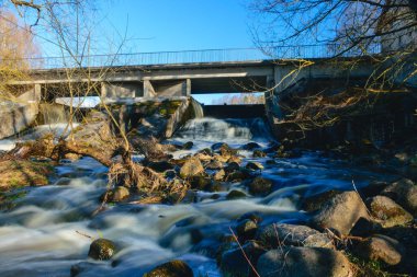 Kayalar arasında hızlı nehir akışı, süt gibi beyaz su, uzun vadede maruz kalma, doğada bahar