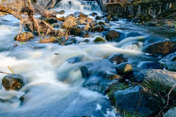 stock image rapid river flow between rocks, water white as milk, long-term exposure, spring in nature