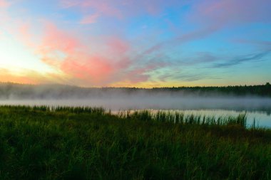 Muhteşem gökyüzü ile harika bir gün doğumu resmi, gölün yüzeyini kaplayan sis, gün doğumu renkli gökyüzü
