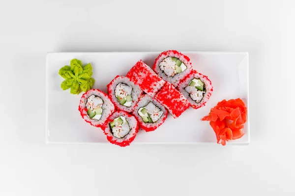 Sushi, wasabi ve zencefilli beyaz bir tabakta 